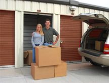 People putting boxes in storage unit